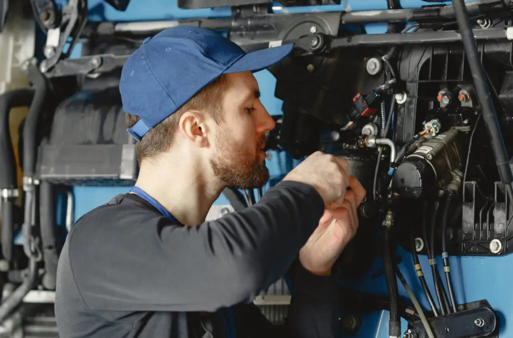 Сar mechanic repairs blue car in garage with tools